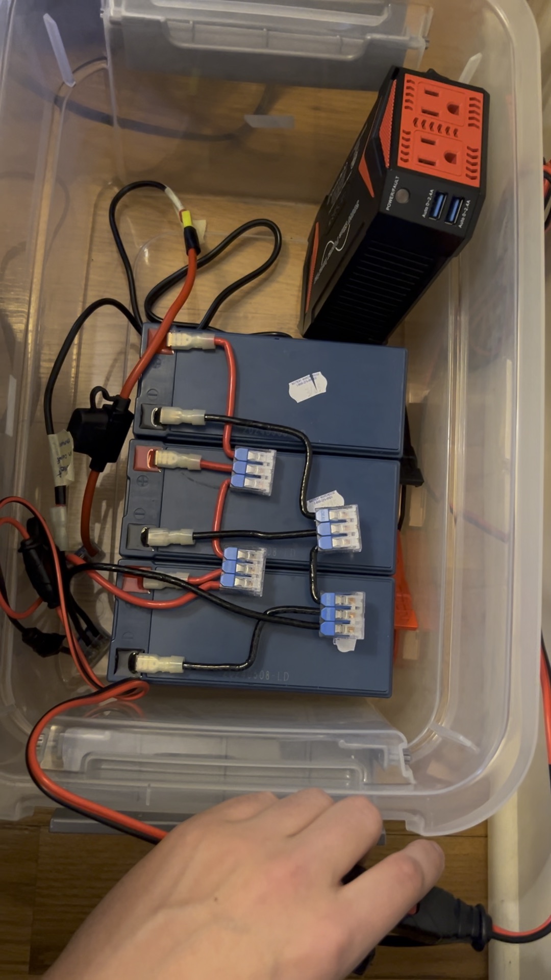 Completed backup power supply — three batteries, inverter, and fuse wired inside a plastic bin